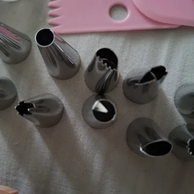 Gros plan sur les douilles inox du kit, ouvertures étoile et unie visibles, posées sur un tissu clair — photo d'un acheteur vérifié